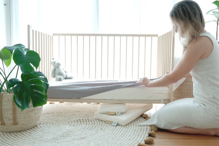 Heveya Junior natural Cot mattress displayed in a baby crib.