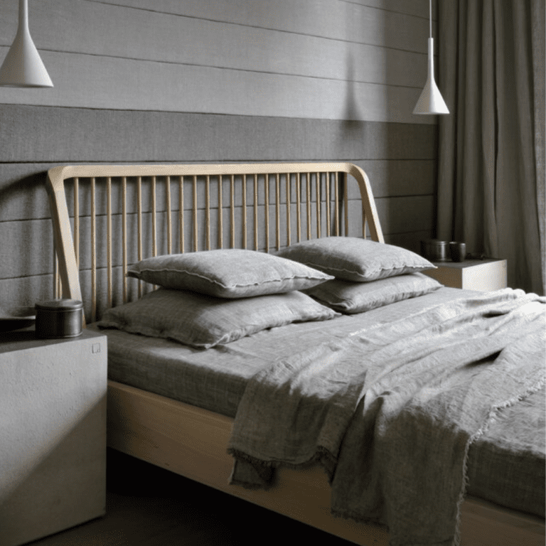 Minimalist Ethnicraft bed frame with open slat headboard and footboard, adding a touch of Scandinavian design to a contemporary bedroom.